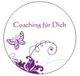 Kreislogo mit lila Schmetterling und Schnörkeln, Text „Coaching für Dich“.