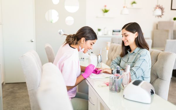Nageldesignerin macht Kundin die Nägel