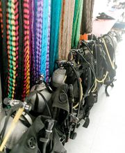 Equipos de buceo y tanques de oxígeno junto a coloridas cuerdas colgadas en la pared.