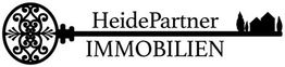 Schwarzer Schlüssel mit Aufschrift "HeidePartner IMMOBILIEN" und Silhouette eines Hauses.