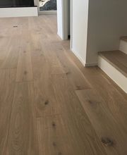 Holzfußboden mit Treppe in einem modernen Raum. Helles, minimalistisches Design.