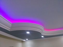 Teto decorativo com luzes LED rosa e iluminação embutida.