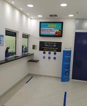 Agência de câmbio com balcões de atendimento e tela exibindo informações.