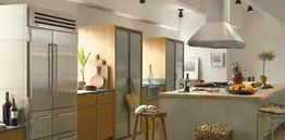 Modern kitchen with stainless steel appliances, wooden cabinets, and a countertop island.