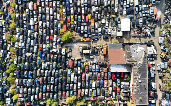 Es ist ein Schrottplatz mit vielen Autos abgebildet.