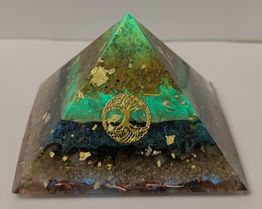 Pyramide mit Goldverzierung und Lebensbaum-Symbol, schimmert in Grün- und Brauntönen.