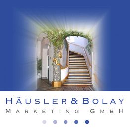 Alte Treppe in einem Gebäude mit Dekorationen, Text "Häusler & Bolay Marketing GmbH".