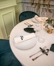 Mesa elegante con platos, copas y servilletas blancas, decorada con flores pequeñas.