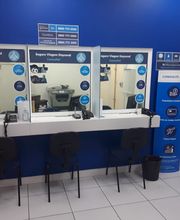 Balcão de câmbio e seguro viagem com cadeiras e materiais de atendimento em sala azul.