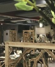 Elegantes Restaurant mit Holzdeko, gedeckte Tische, gemütliches Ambiente.