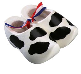 Weiße Babyschuhe mit schwarzen Flecken und rotem, weißem und blauem Band.