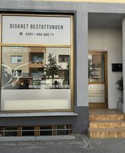 Fassade eines Bestattungsunternehmens mit der Aufschrift „Diskret Bestattungen“ und Kontaktdaten.