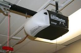 Ceiling-mounted LiftMaster garage door opener with a red manual release cord hanging down.