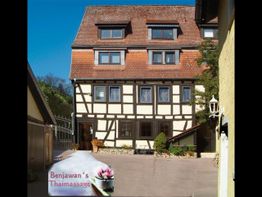 Fachwerkhaus mit rotem Dach, Hofeinfahrt und Schild: "Benjawan's Thaimassage" mit Lotusblume.