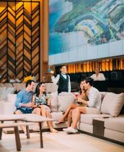 Personas conversan en un salón moderno con pantallas grandes y decoración elegante.