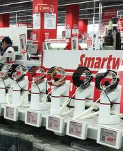 Esposizione di smartwatch su supporti bianchi in un negozio di elettronica.