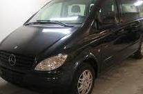 Schwarzer Van in einer Garage, von vorn seitlich fotografiert.