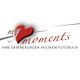 Logo mit Herz, Text "my moments" und Slogan "Ihre Erinnerungen in einem Fotobuch".