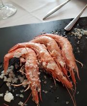 Camarones con sal gruesa sobre una tabla negra.