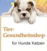 Welpe liegt auf Schild mit Text: "Tier-Gesundheitsshop für Hunde Katzen". Blume im Hintergrund.