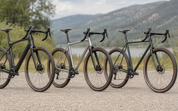 Drei Gravel Bikes aus Carbon, Aluminium und Stahl vor einer Berglandschaft.