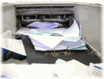 Ein überfüllter Drucker mit gestauten Papierstapeln.