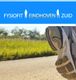 Hardlopende schoenen op een pad met grasveld, tekst: "Fysiofit Eindhoven Zuid".