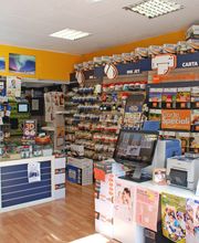 Negozio di forniture per ufficio con scaffali pieni di cartucce, toner e carta.