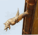 Wasserspeier in Form eines Tieres an einem Kupferrohr auf einem Gebäude.