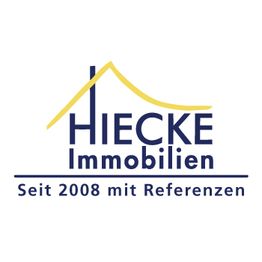 Logo von Hiecke Immobilien mit gelbem Dach und Text: "Seit 2008 mit Referenzen".