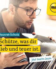 Mann betrachtet eine Schallplatte; Text: "Hausrat-Schutz: Schütze, was dir lieb und teuer ist."