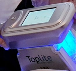 Gadget mit Display und der Aufschrift "TopLite". Es leuchtet blau und hat Tasten.