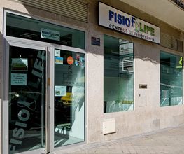 Fachada de un centro de fisioterapia con el letrero “Fisio Life” en un día soleado.