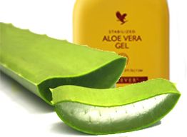 Aloe-Vera-Blatt mit Aloe-Vera-Gel in gelber Flasche im Hintergrund.