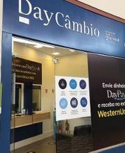 Loja de câmbio com fachada azul, destacando serviços de envio de dinheiro e Western Union.