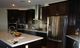 Modern kitchen with dark cabinets, stainless steel appliances, and a central island.