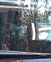 Auto-Frontscheibenwechsel: Handwerker montiert neue Windschutzscheibe an einem schwarzen Fahrzeug.