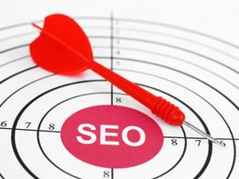 Red dart hitting bullseye labeled "SEO" on target, symbolizing successful search optimization.
