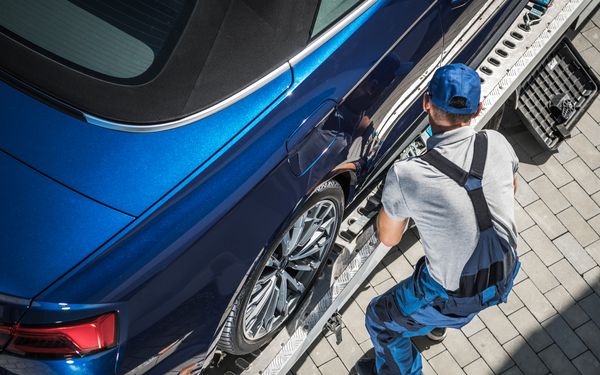 Abschleppservice schleppt einen blauen Firmenwagen ab.