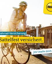 Mann fährt Fahrrad über eine Brücke bei Sonnenuntergang. Text: "Fahrrad-Versicherung: Sattelfest versichert."