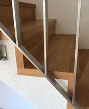 Holztreppe mit Metallgeländer in modernem Design.