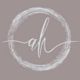 Stylized "ah" initials in white cursive, encircled by a textured circle on a beige background.