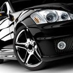 Schwarzer Sportwagen im Close-up, zeigt Scheinwerfer und glänzende Felgen.