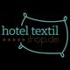 Logo mit Text "hotel textil shop.de" auf schwarzem Hintergrund, umrahmt von einer Kissen-Skizze.