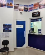 Interior de escritório com portas azuis, cartazes nas paredes e balcão de atendimento.