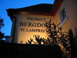 Ansicht einer beleuchteten Hauswand mit der Aufschrift "Weingut Bergdolt St. Lamprecht 1754".