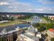Blick über Dresden mit der Elbe, Brücken und historischen Gebäuden unter blauem Himmel.