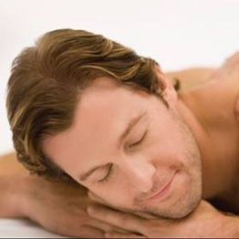 Man relaxing with eyes closed, resting his head on folded arms against a white background.