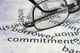 Glasses on a page with financial terms like "borrower" and "commitment" in bold text.