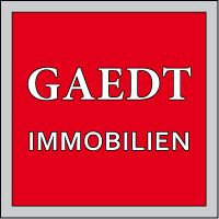 Rotes Logo mit weißem Text: "GAEDT IMMOBILIEN" in einem grauen Rahmen.
